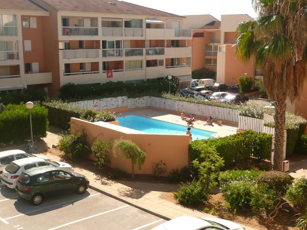 an apartment complex with a swimming pool and a parking lot at Le Ciel Bleu in La Seyne-sur-Mer