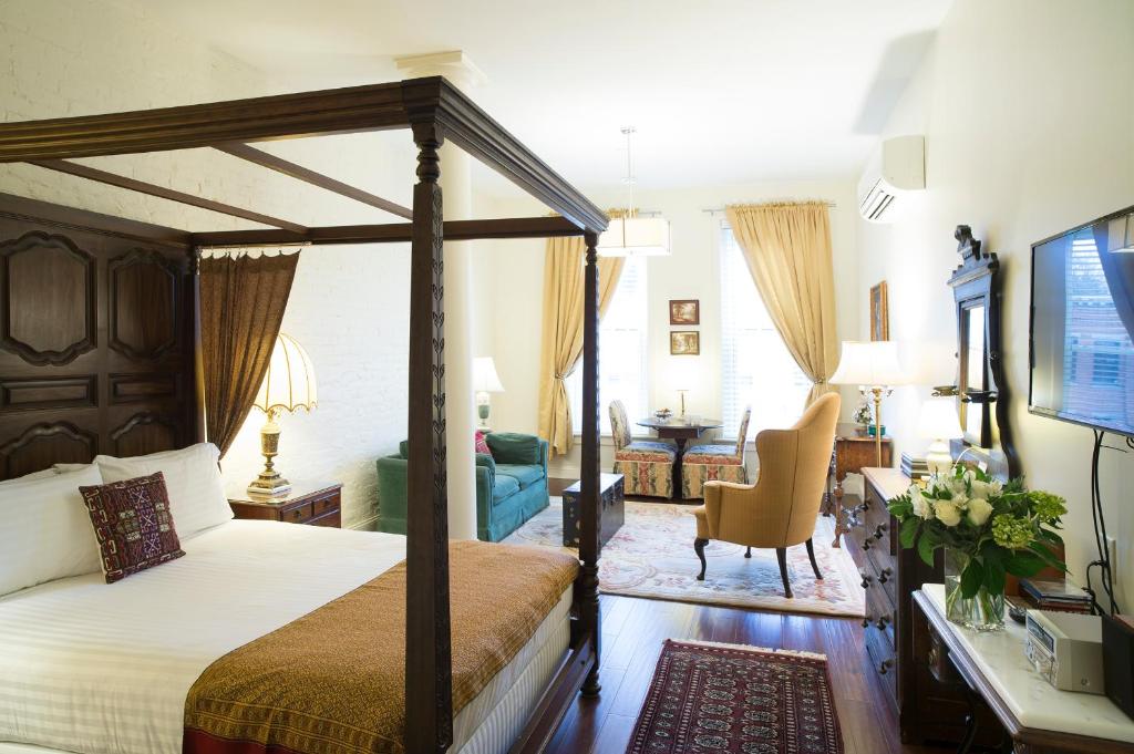 a bedroom with a canopy bed and a living room at The Barrington in Great Barrington