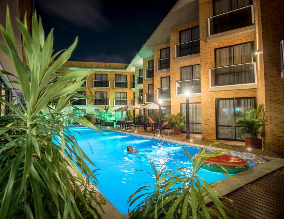 a swimming pool in front of a building at night at Bessa Beach Hotel in João Pessoa