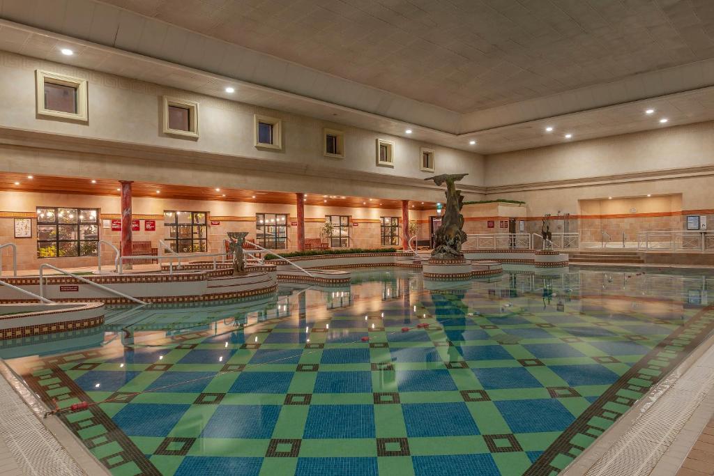 a large swimming pool with a statue in a building at Glenroyal Hotel in Maynooth