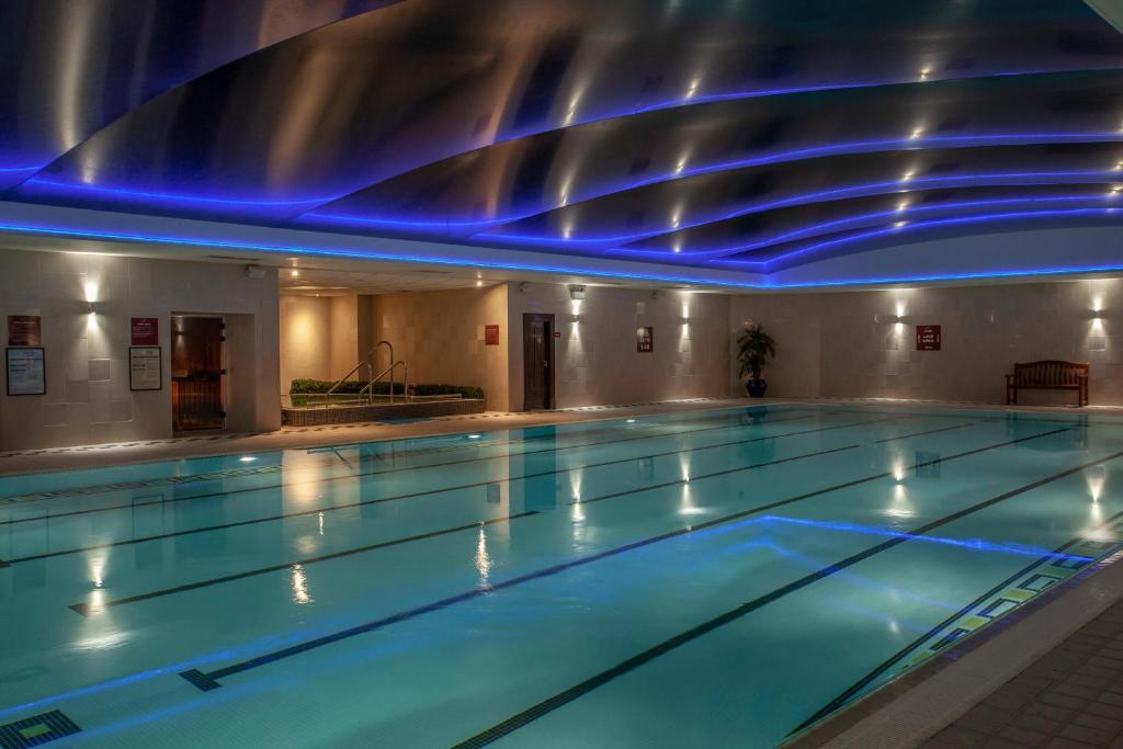 a swimming pool with blue lights in a building at Glenroyal Hotel in Maynooth