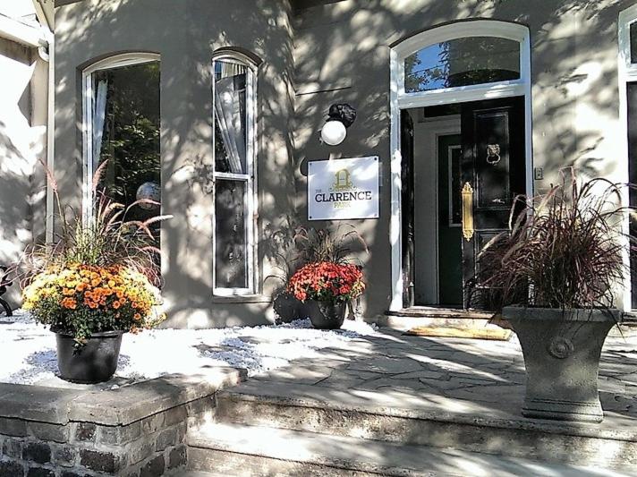 um edifício com dois vasos de plantas na frente de uma porta em The Clarence Park em Toronto