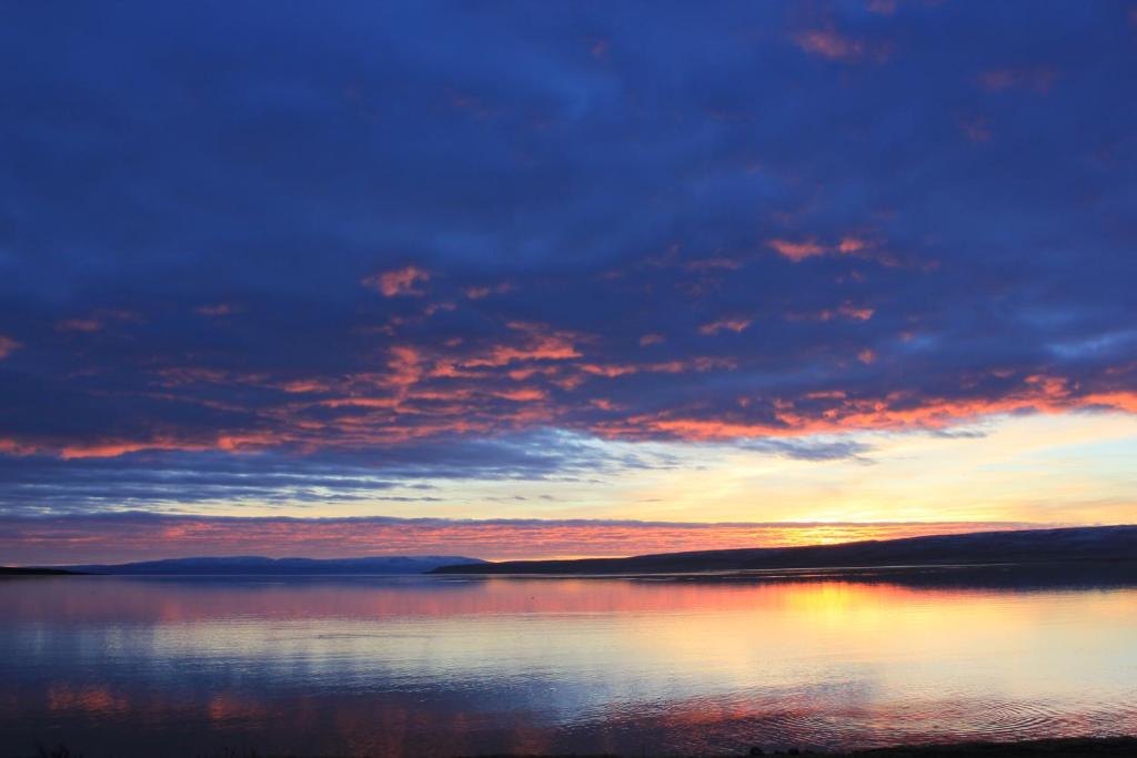 una puesta de sol sobre un gran cuerpo de agua en Kriukot, en Hólmavík