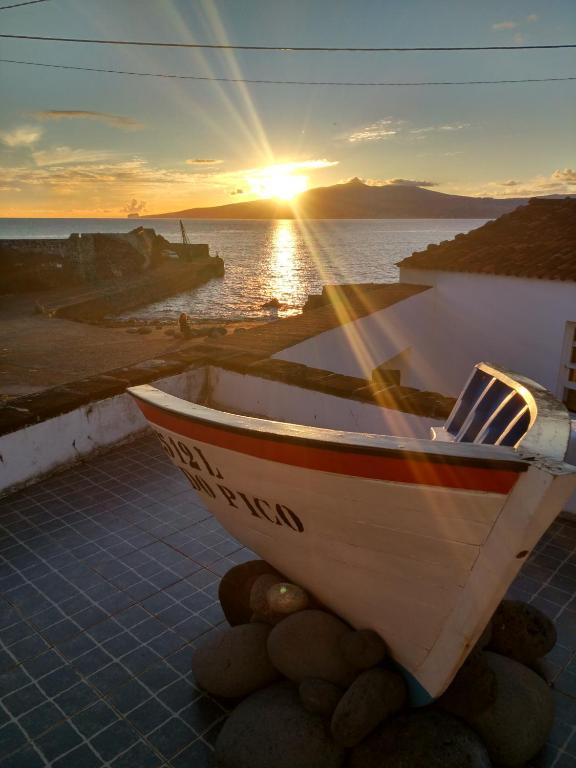 a boat sitting on the ground with the sunset in the background at Casa do Guardião in Madalena