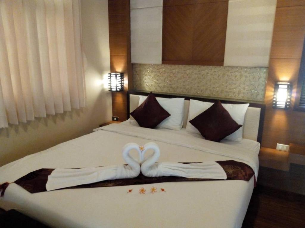 a hotel room with a bed with two wedding towels at Sisina Resort and Spa in Prachuap Khiri Khan