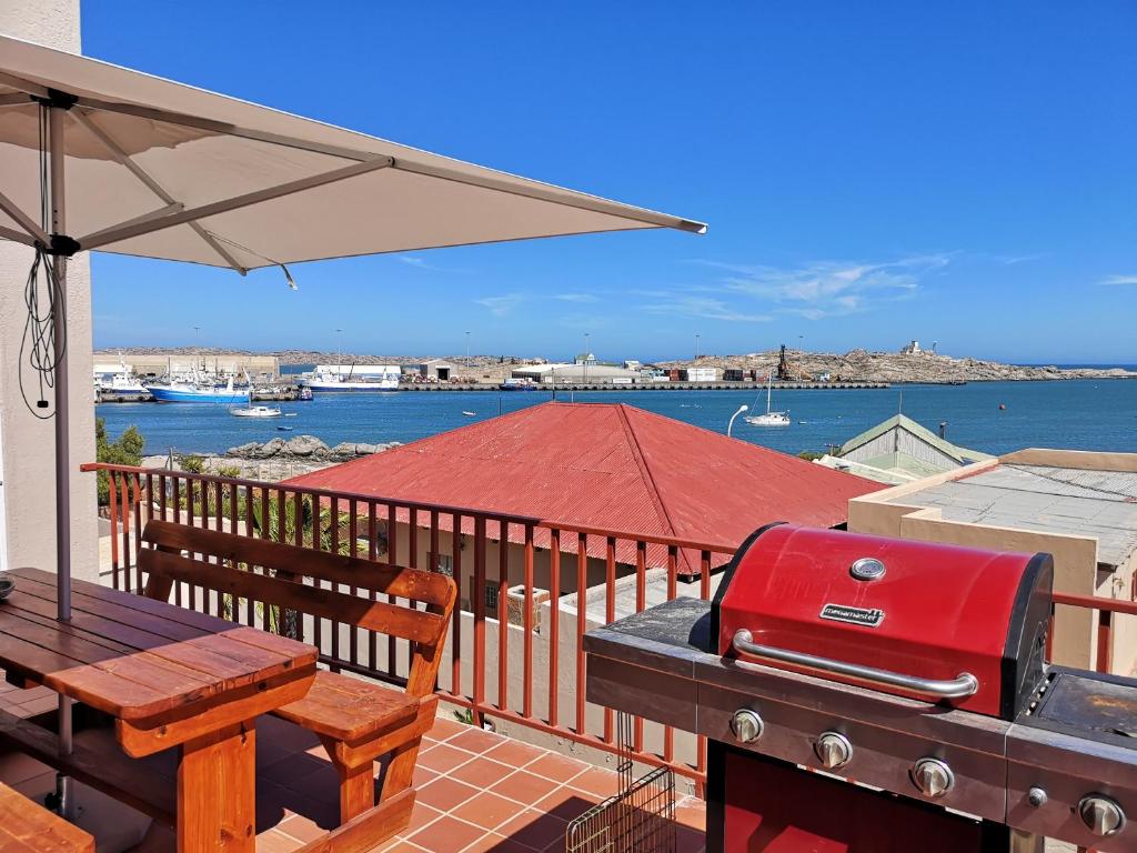 a bbq grill on a deck with a view of the water at Starfish Guesthouse in Lüderitz