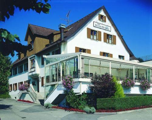 un grand bâtiment blanc avec des fleurs devant lui dans l'établissement Hotel Bayerischer Hof Rehlings, à Weißensberg