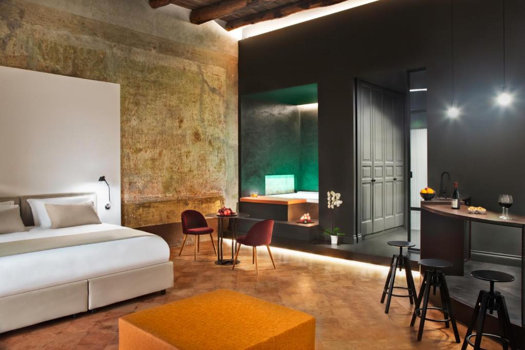 a bedroom with a bed and a desk and chairs at Artemisia Domus - Centro Storico in Naples