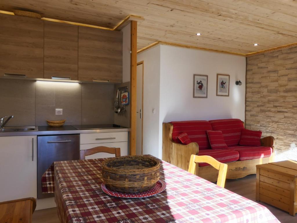 kuchnia i salon ze stołem i czerwoną kanapą w obiekcie Résidence Asphodeles w Méribel