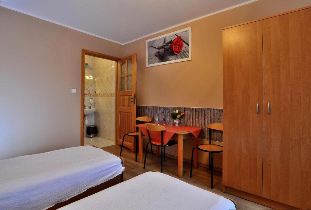 a small room with a bed and a table and chairs at Zajazd Zagłoba in Widoma