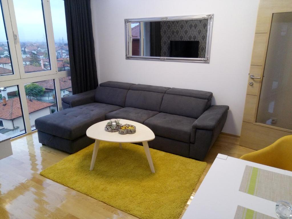 ein Wohnzimmer mit einem Sofa und einem Tisch in der Unterkunft Anja in Bijeljina