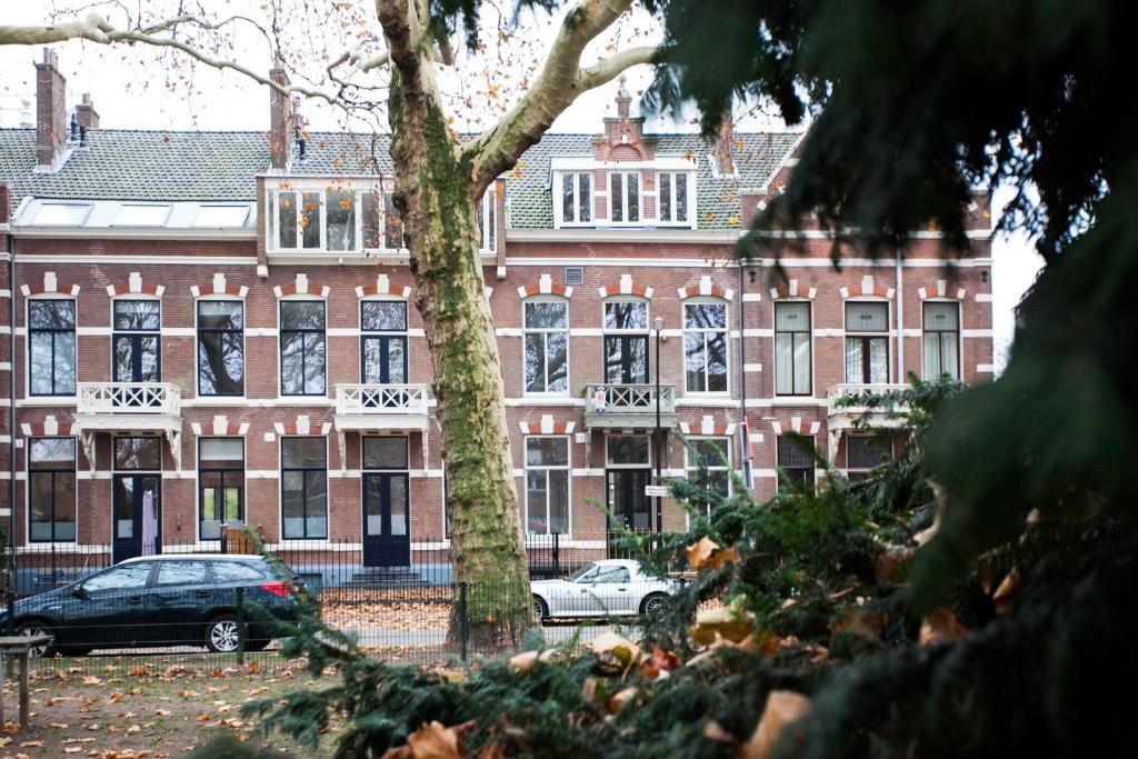 un grande edificio in mattoni con macchine parcheggiate di fronte di Oranjepark a Dordrecht