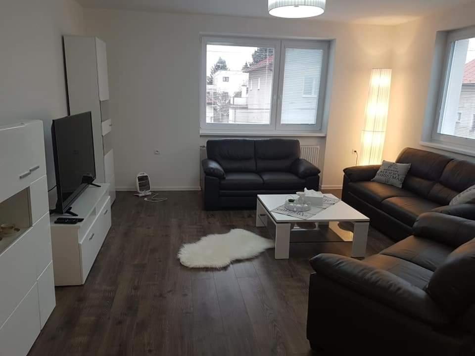 a living room with a couch and a tv and a table at Apartmán Martin in Martin