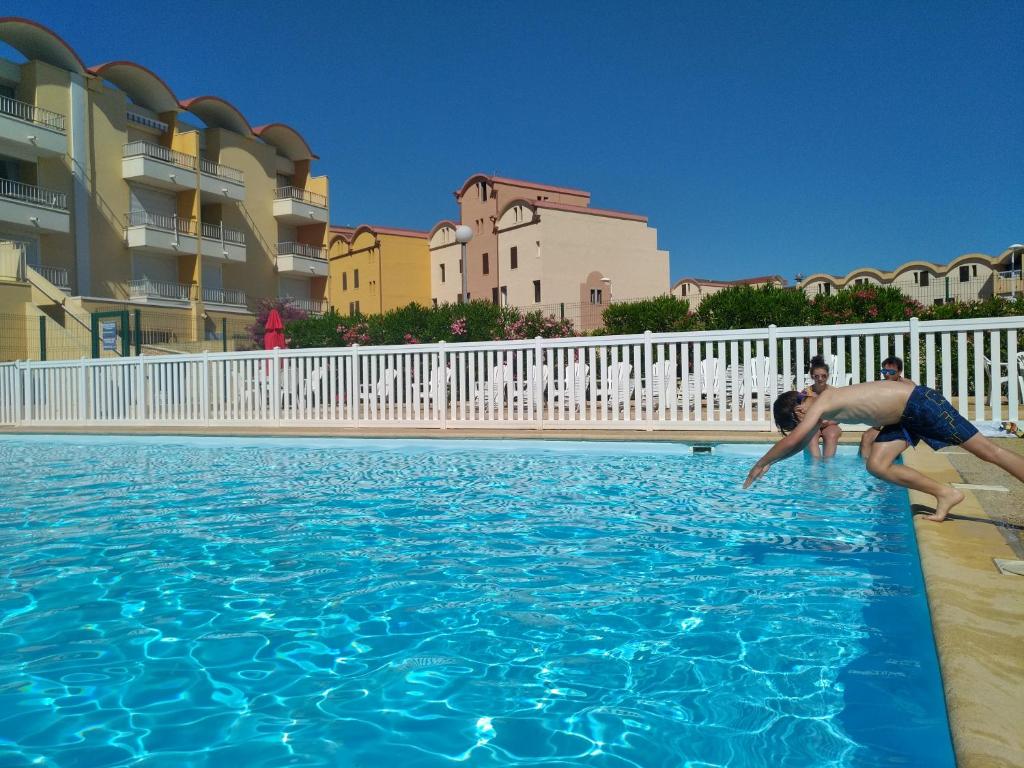 un homme et un garçon jouant dans une piscine dans l'établissement logis 149, à Gruissan