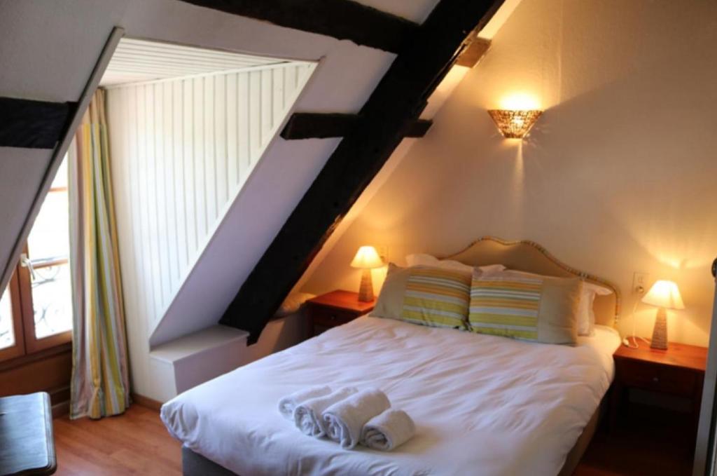 um quarto com uma cama com duas toalhas em Le Poisson Ivre em Dinan