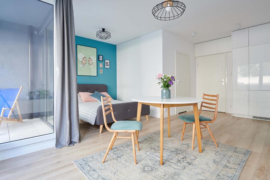 een eetkamer met een tafel en stoelen en een slaapkamer bij Mint Apartment in Poznań