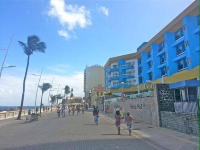 un grupo de personas caminando por una calle junto a una playa en Bahia Flat Apt 124 Farol da Barra, en Salvador