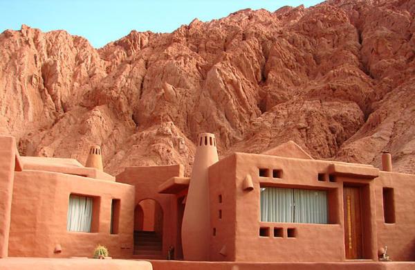 un edificio frente a una montaña rocosa en Los Colorados Cabañas Boutique en Purmamarca