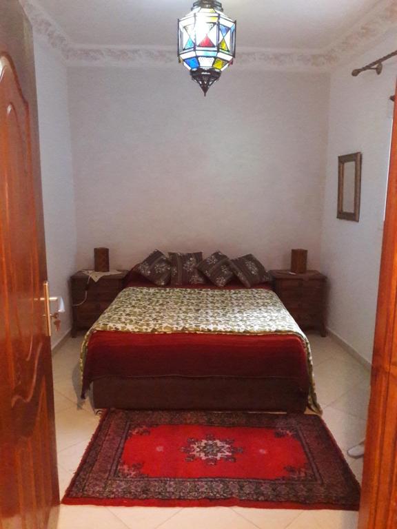 a bedroom with a bed and a chandelier at appartement traditionnel et contemporain, au coeur du kasbah in Tangier