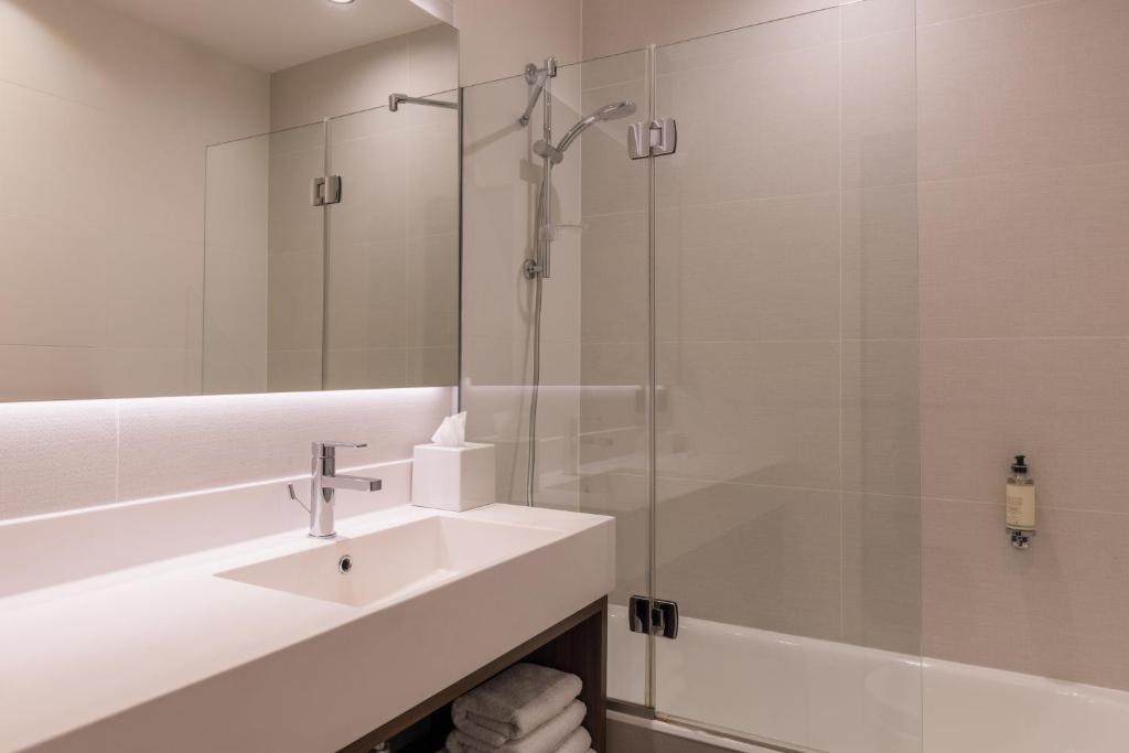 a bathroom with a sink and a glass shower at Best Western Select Hotel in Boulogne-Billancourt