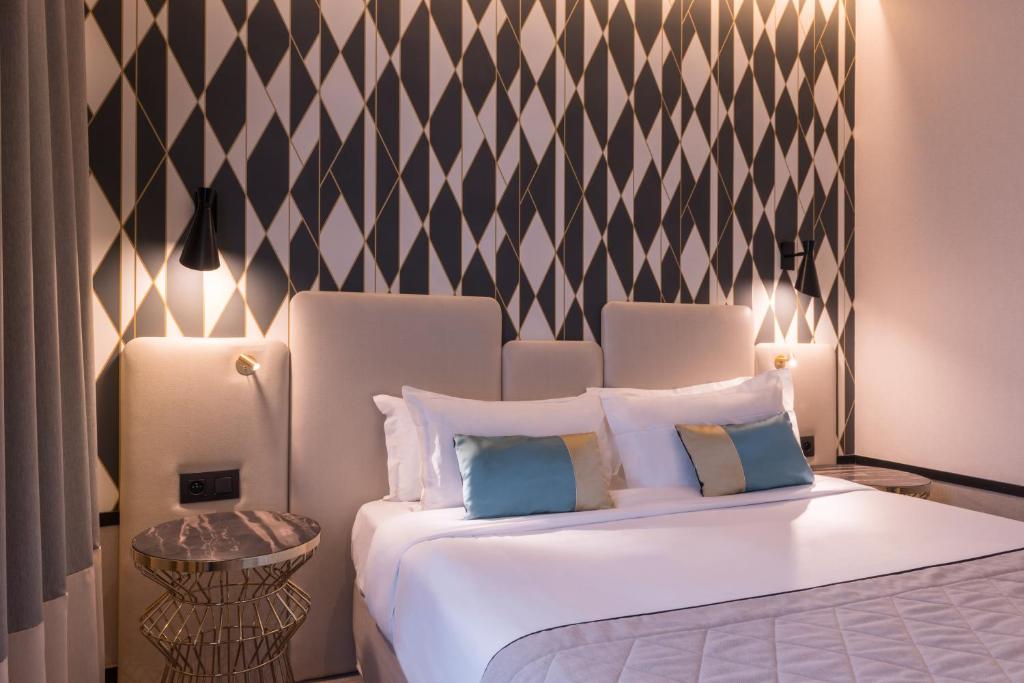 a bedroom with a white bed with a black and white wall at Best Western Select Hotel in Boulogne-Billancourt