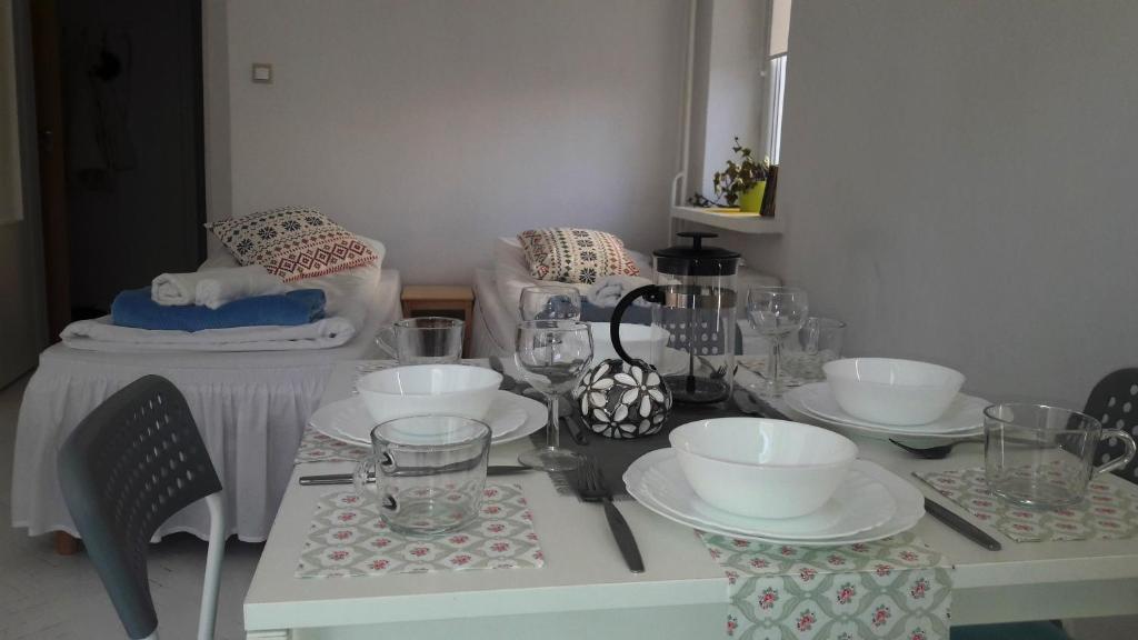 ワルシャワにあるOgrodowa Apartmentsの白いテーブル(お皿、お皿付)