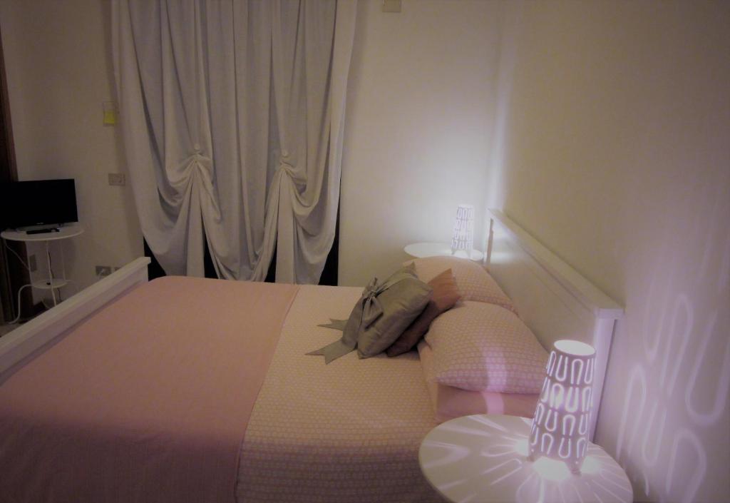 1 dormitorio con 1 cama y una ventana con cortinas blancas en Zara Apartment, en Treviso