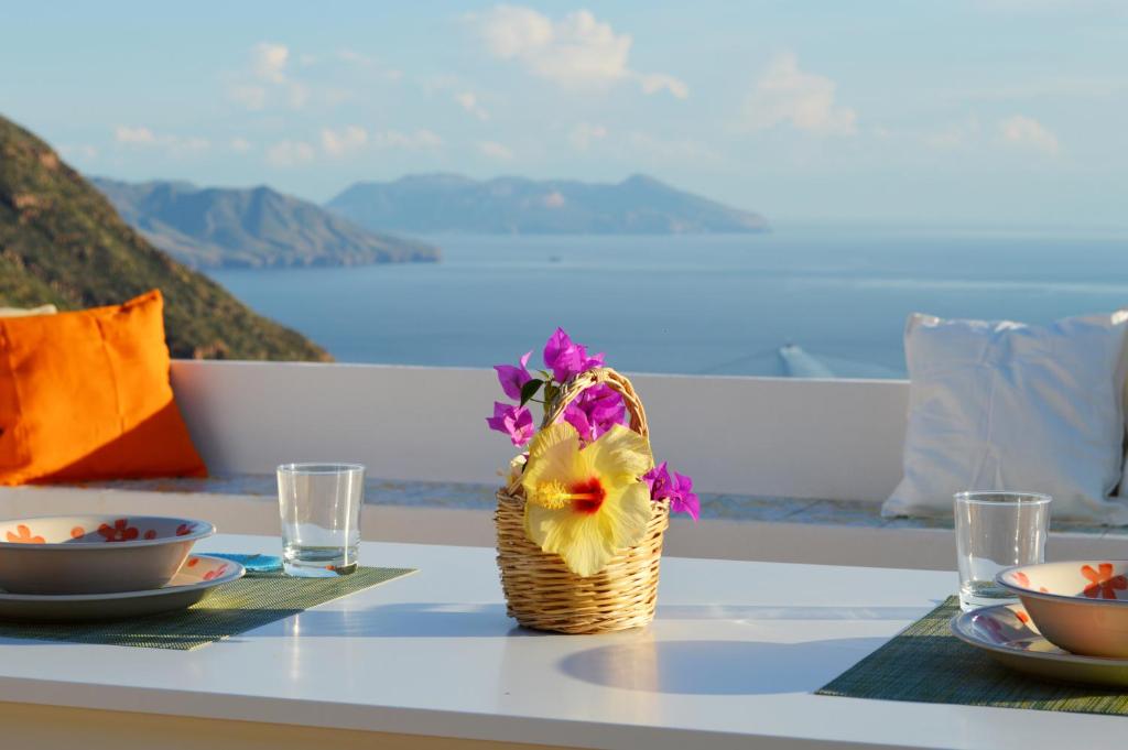 Una mesa con una cesta de flores. en Orizzonte Relais, en Leni