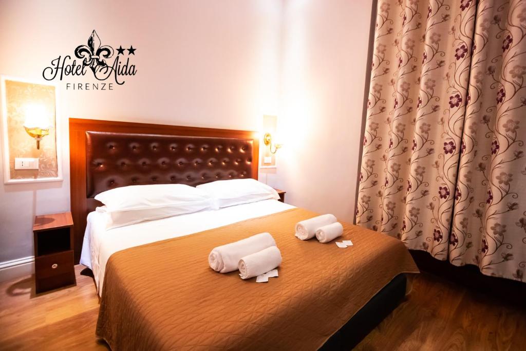 una camera d'albergo con due asciugamani su un letto di Hotel Aida a Firenze