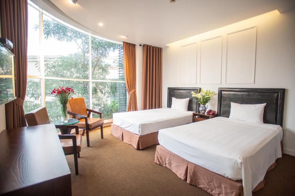 a hotel room with two beds and a window at Dinh Hotel in Hanoi