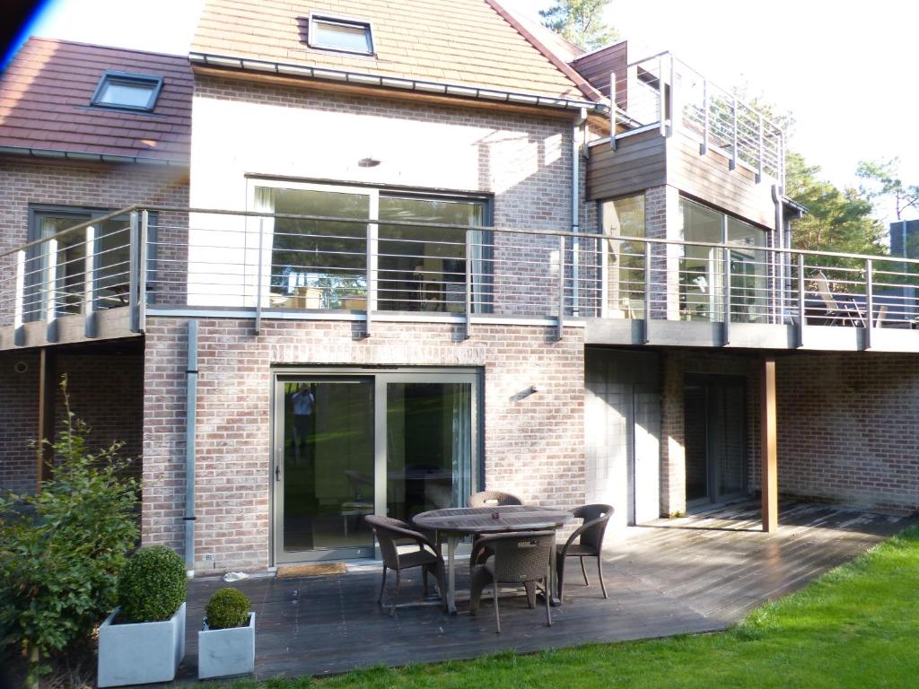 a brick house with a patio with a table and chairs at La Florentine in Hardelot-Plage