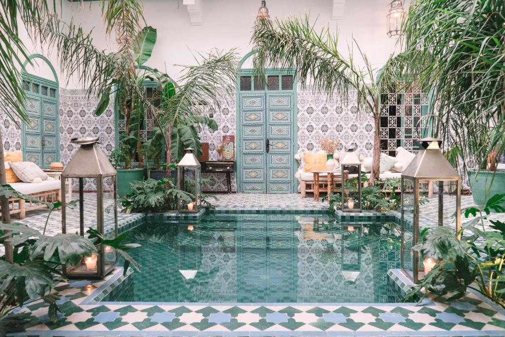 a pool in the middle of a room with plants at Riad BE Marrakech in Marrakech