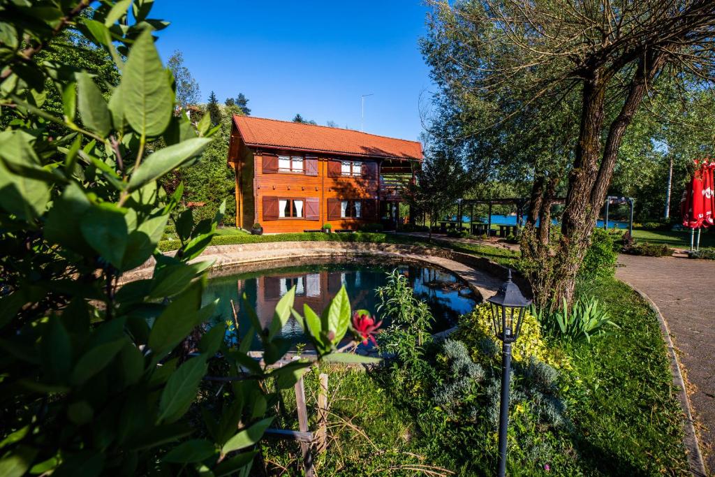 a house with a pond in front of it at Apartment Mrežnička kuća in Duga Resa