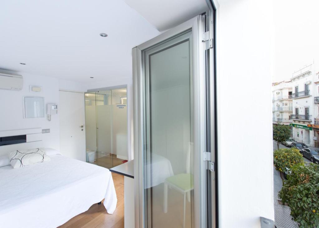 セビリアにあるCasa Feria 60のベッドルーム1室(ベッド1台付)、スライド式ガラスドアが備わります。