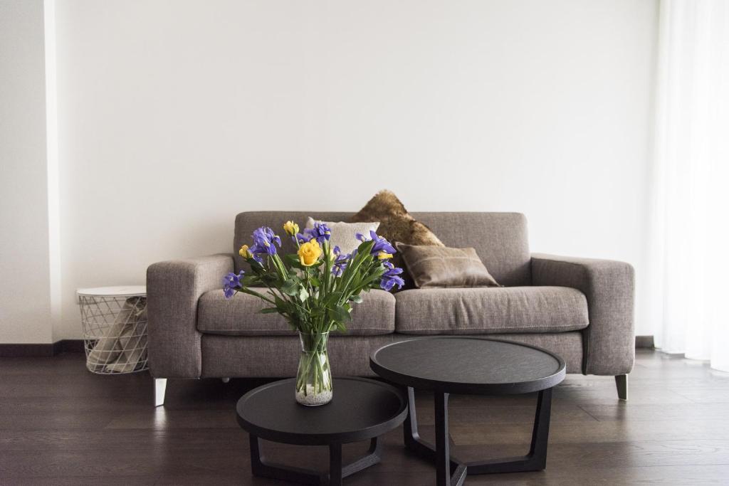 un soggiorno con divano e vaso con fiori di Design & New Center Apartments a Milano