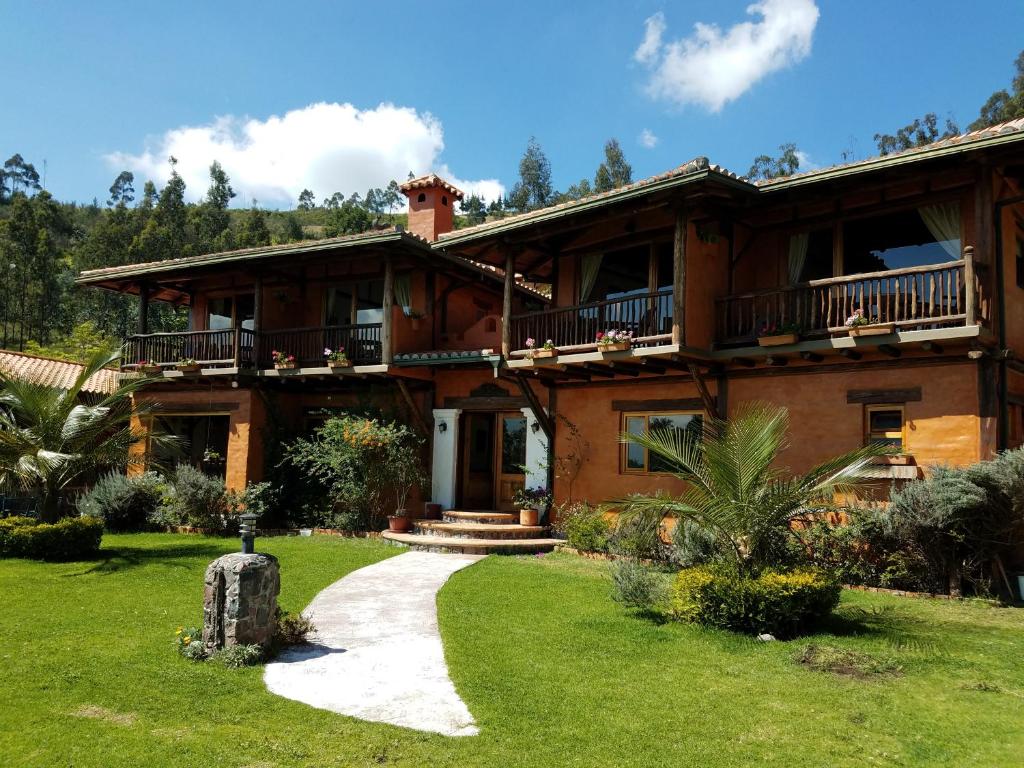 ein großes Haus mit einem Gehweg davor in der Unterkunft Ilatoa Lodge in Quito