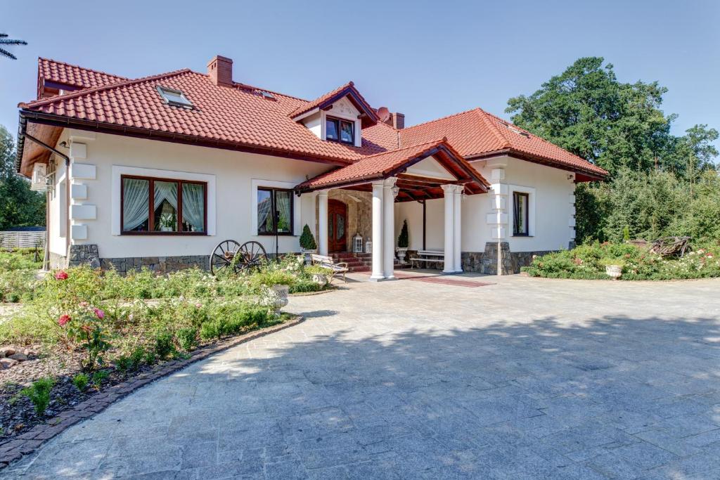 a house with a red roof and a driveway at Dworek Kurowski in Szczecin