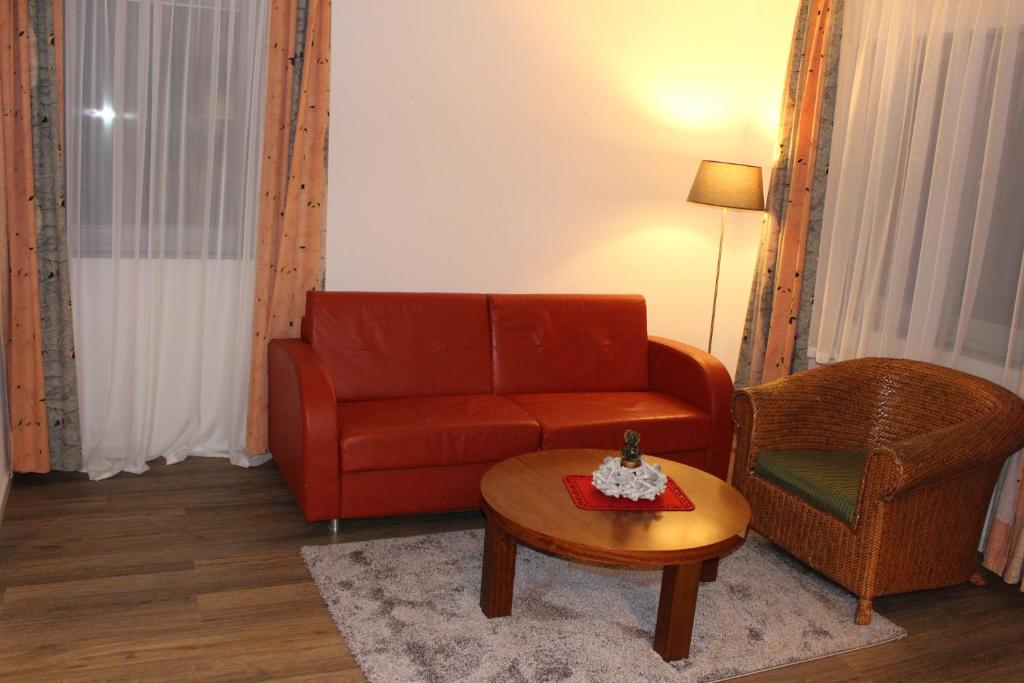 ein Wohnzimmer mit einem roten Sofa und einem Stuhl in der Unterkunft I.M.Apartments 42 m² für 2 Personen in Düsseldorf