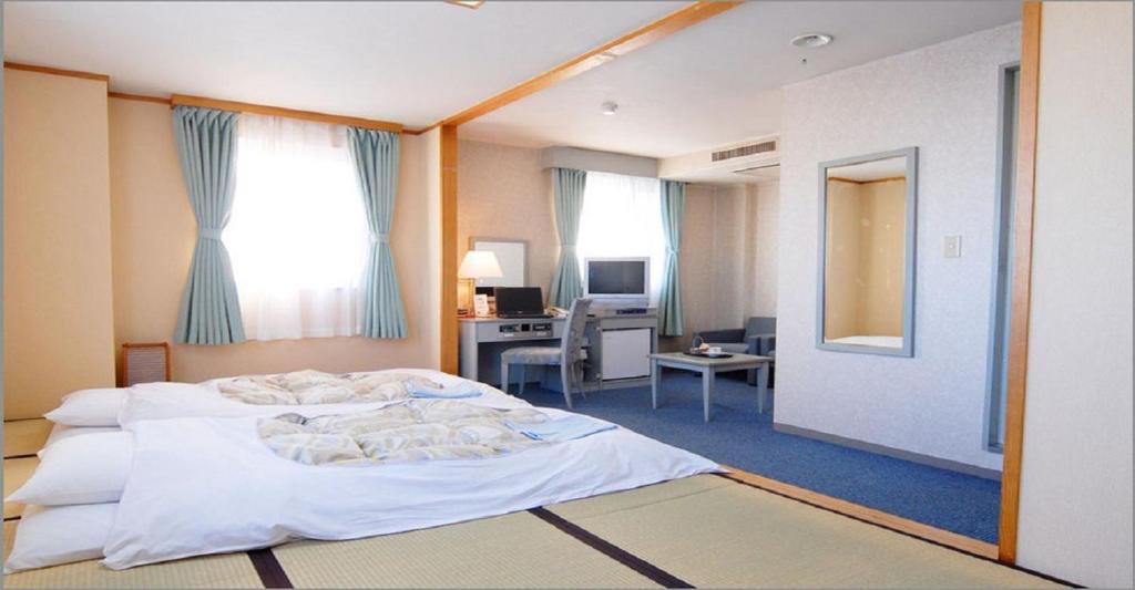 Seagrande Shimizu Station Hotel / Vacation STAY 8213 في شيزوكا: غرفة نوم مع سرير ومكتب مع جهاز كمبيوتر