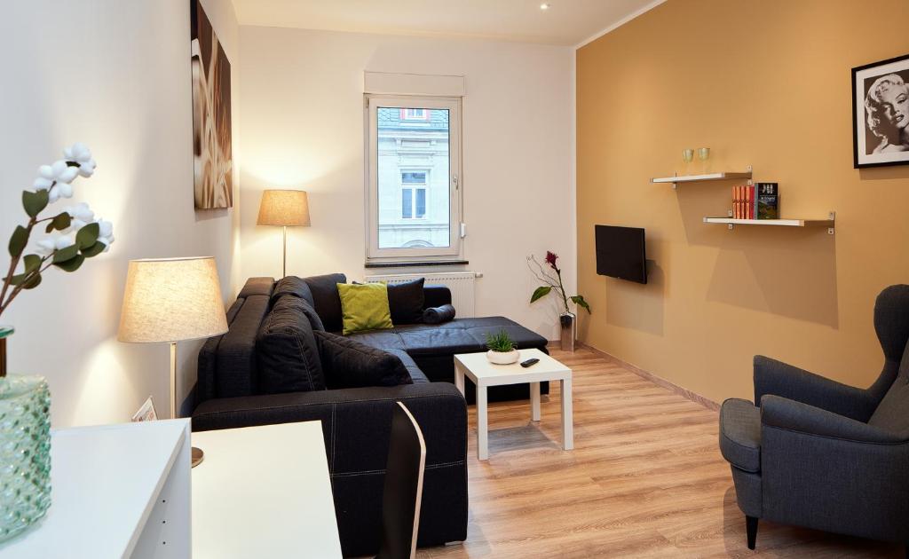 uma sala de estar com um sofá e uma mesa em Apartments 4 YOU - Goethestraße em Fürth