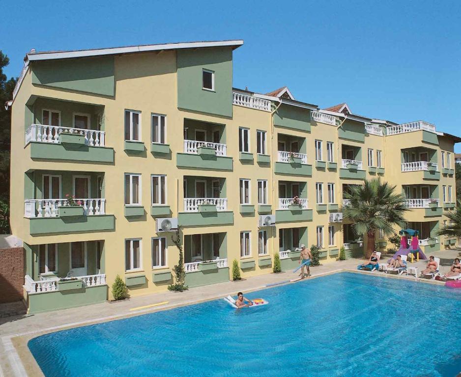 a group of people in a swimming pool in front of a building at Club Sunset Apartments in Marmaris
