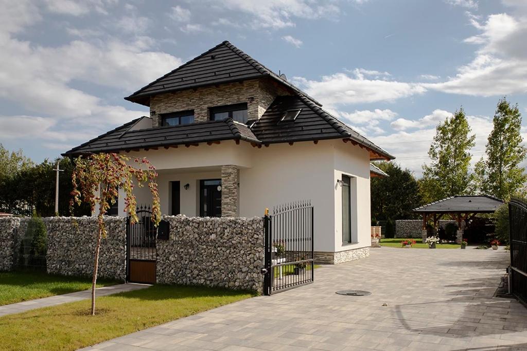 una pequeña casa blanca con techo negro en Győri vendégház, en Demjén