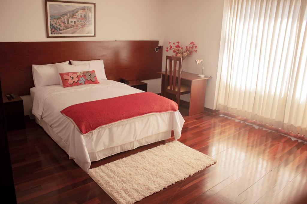 une chambre avec un grand lit et un parquet dans l'établissement Vilmor Hotel Boutique, à Trujillo