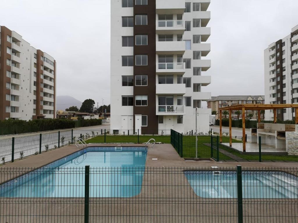 kompleks apartamentów z basenem przed budynkiem w obiekcie Apartamento la serena a pasos del mar w mieście La Serena