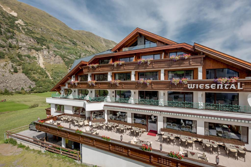 a hotel building with tables and chairs at Hotel Wiesental in Obergurgl