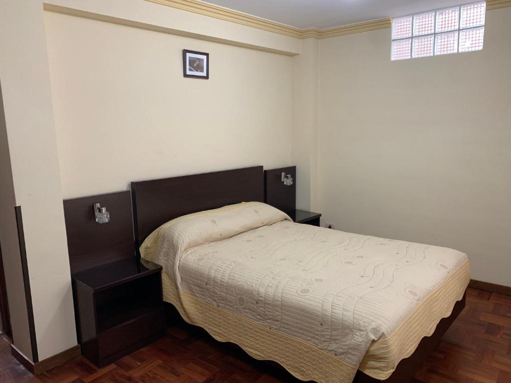 a small bedroom with a bed and a window at Residencial Alta Vista in La Paz