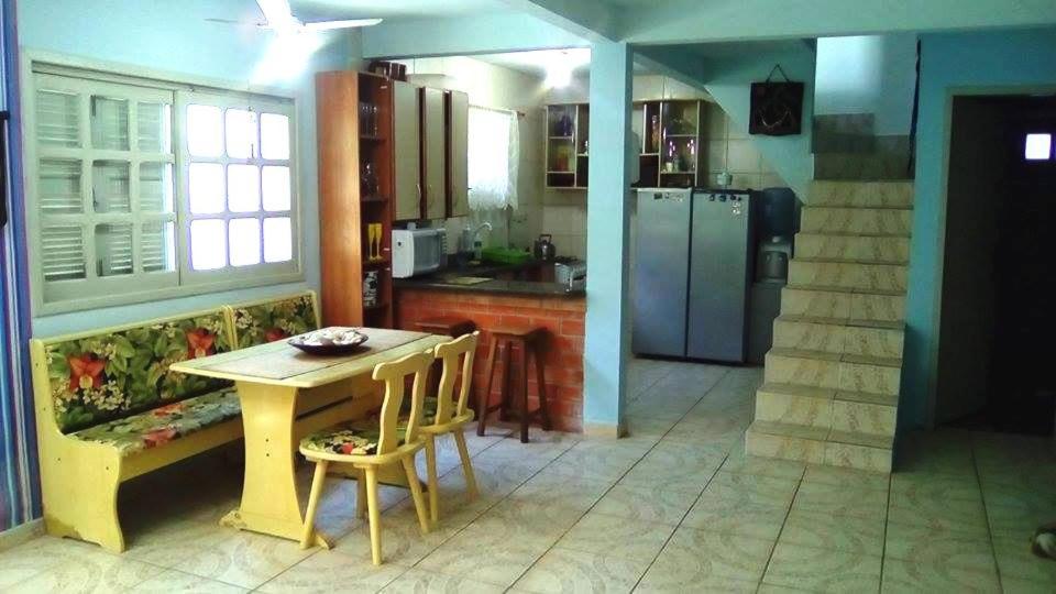 a kitchen with a table and chairs in a kitchen at TRIPLEX NA PONTA DO PAPAGAIO in Palhoça