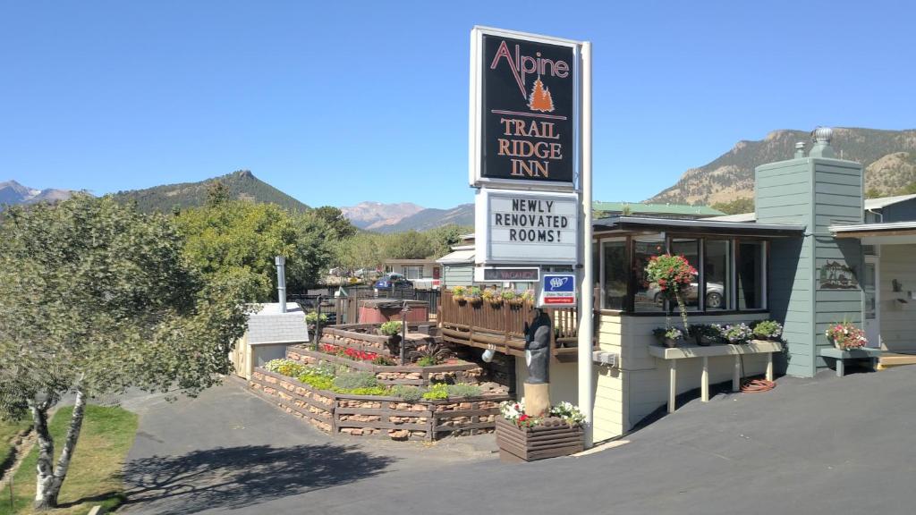 un panneau indiquant une auberge de jeunesse avec des plantes dans l'établissement Alpine Trail Ridge Inn, à Estes Park