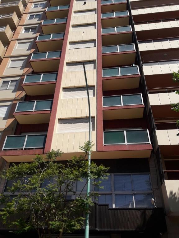 un edificio de apartamentos alto con una luz de la calle delante de él en Depto. 2 ambientes en Mar del Plata