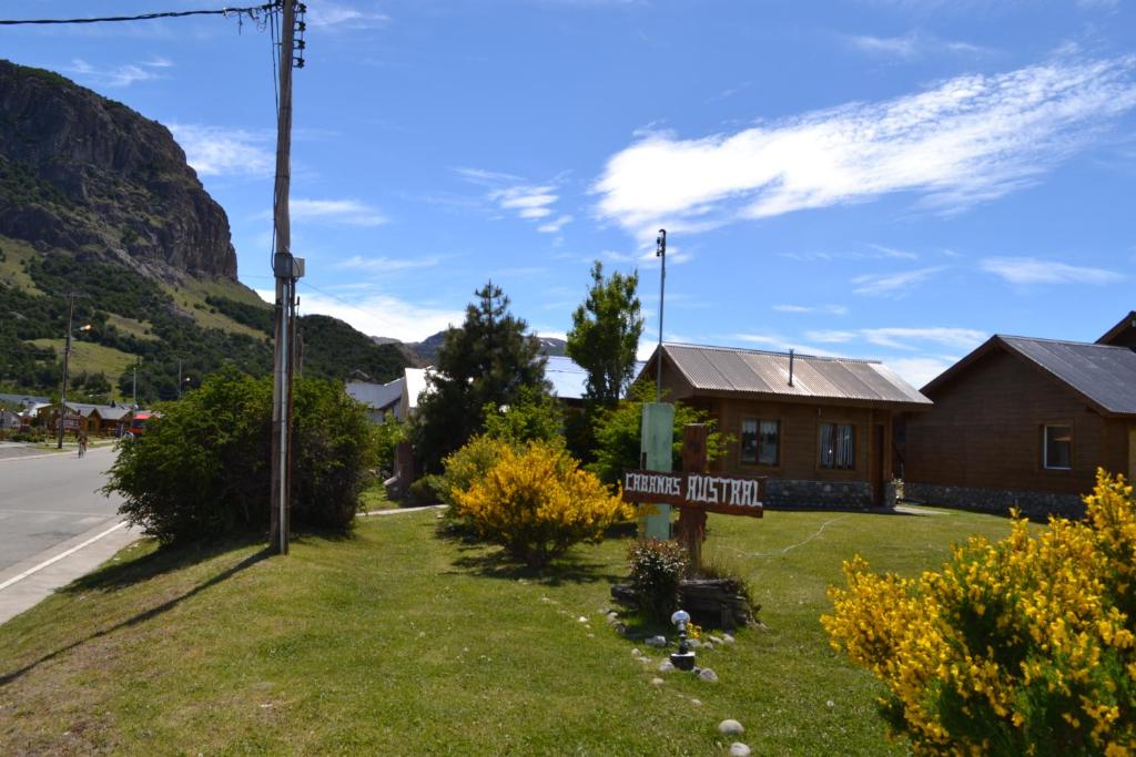 una señal para una casa con una montaña en el fondo en Cabañas Austral en El Chaltén